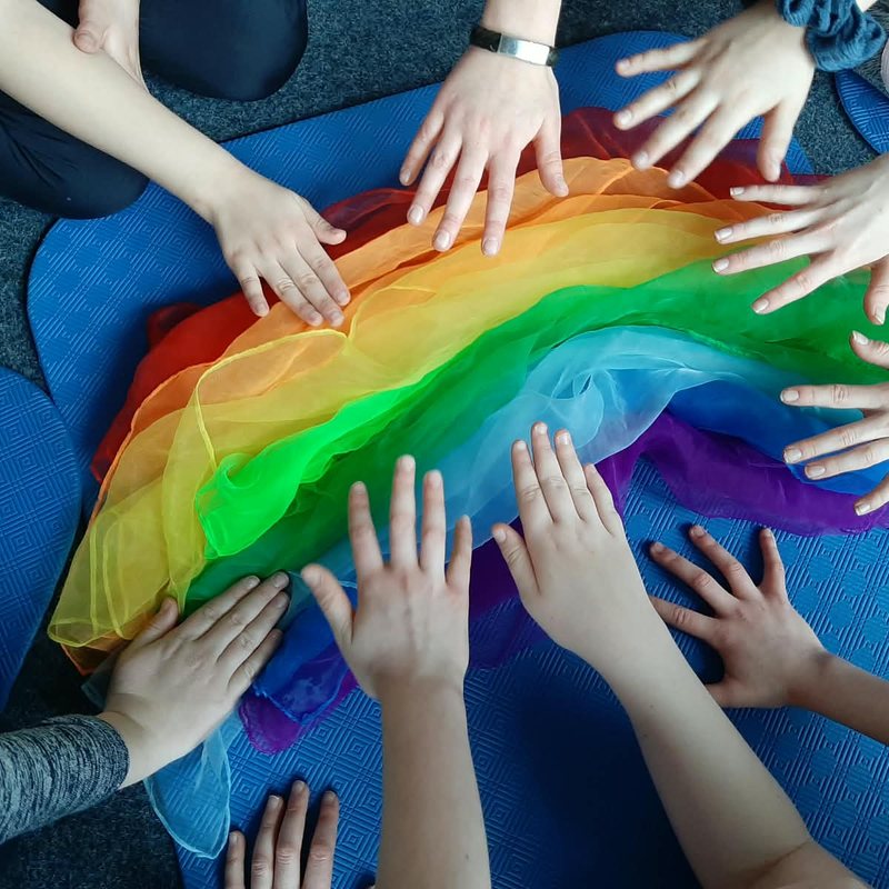 Kinderhände auf bunten Tüchern